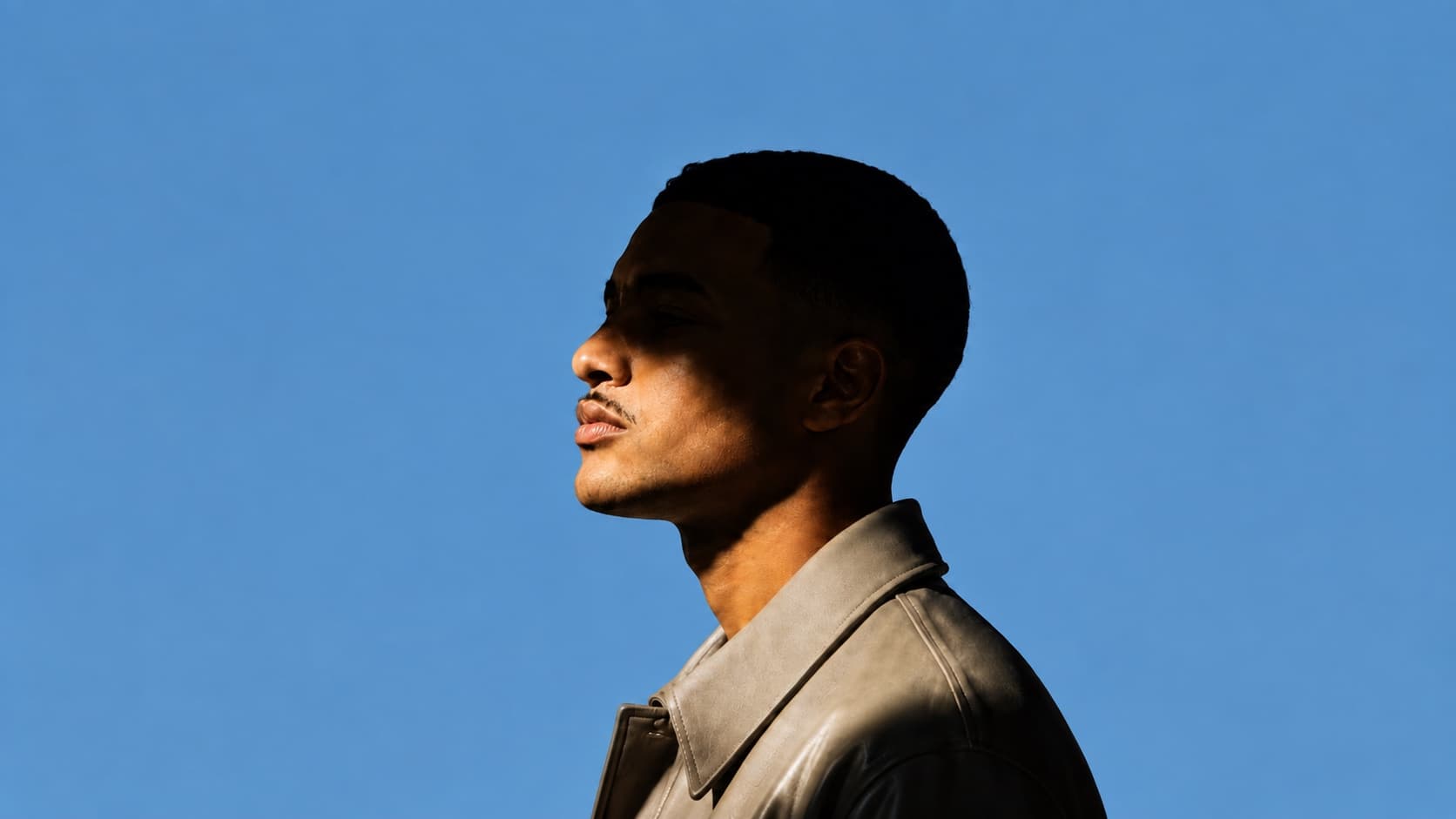 Joshua Herbert in profile on a blue backdrop